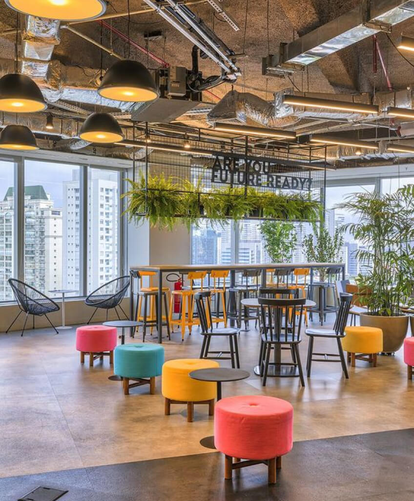 A long wooden desk, plastic chairs and desk lamps 